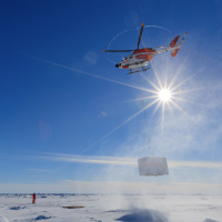 A helicopter transports equipment onto the ice