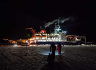 ship with lights on against dark night