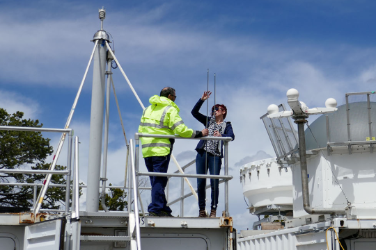 two people on building, checking equipment