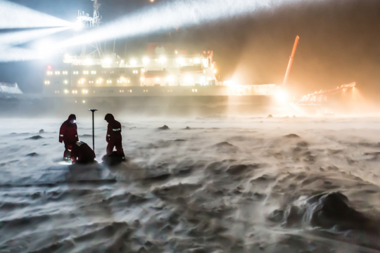 scientists in blowing snow, dark