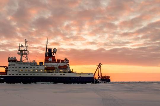 The RV Polarstern parked in ice. Photo: Stefan Hendricks/AWI The Polarstern ship parked in Arctic ice at sunset.