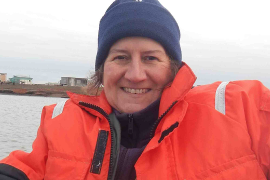 Scientist in warm clothing on a boat.