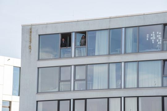 In this photo provided by the Alfred Wegener Institute and taken on May 6, 2020, MOSAiC participants stand at the window of their rooms in the hotel, where they are in quarantined before returning to the MOSAiC expedition, in Bremerhaven, Germany. Photo: Esther Horvath