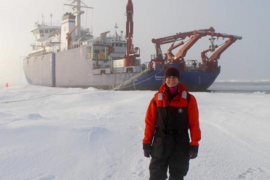 Maddie Smith in the Beaufort Sea in 2015, in front of the R/V Sikuliaq. “It was my first time standing on sea ice (over thousands of meters of water!), so I was pretty excited.” (Photo courtesy of Maddie Smith)