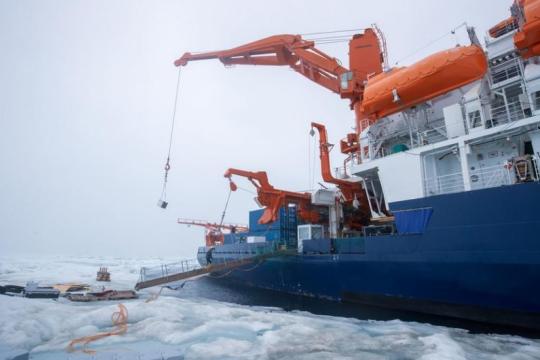 The ship’s crane lifts instruments from the floe. Photo: Lianna Nixon/CIRES and CU Boulder