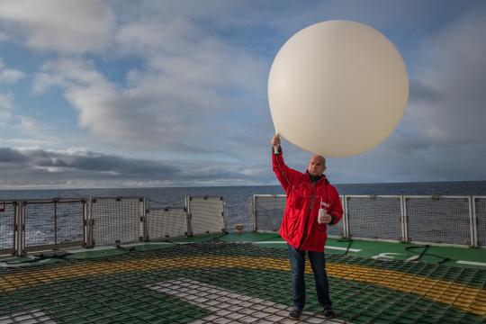 Juergen Graeser launches a weather balloon on the helicopter deck of Polarstern research vessel in 2019. Credit: Esther Horvath